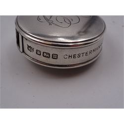 Early 20th century silver tape measure, of circular form, engraved with monogram, inscribed Chesterman Sheffield England to edge, hallmarked James Chesterman & Co, Sheffield 1912 together with a 1930s silver cheroot holder case, hallmarked Joseph Gloster Ltd, Birmingham 1938 containing a cheroot holder with hallmarked 9ct gold collar 