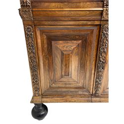 Late 17th century Flemish/Dutch rosewood and oak ‘Zeeuwse Kast’ or cupboard, projecting cornice carved with three putti masks, the uprights carved with lion masks over ribbons, flower heads and foliage, enclosed by four geometric panelled doors, lower central upright carved with flower head over foliate ribbon with bird among foliage, the escutcheon hidden by swivel berry carved cover, interior fitted with shelves, two drawers and shallow hinged cupboard, on two large turned and ebonised feet, circa 1680