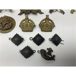 Over thirty British and Continental military metal badges; together with quantity of shoulder titles, collar dogs, rank pips, uniform buttons etc