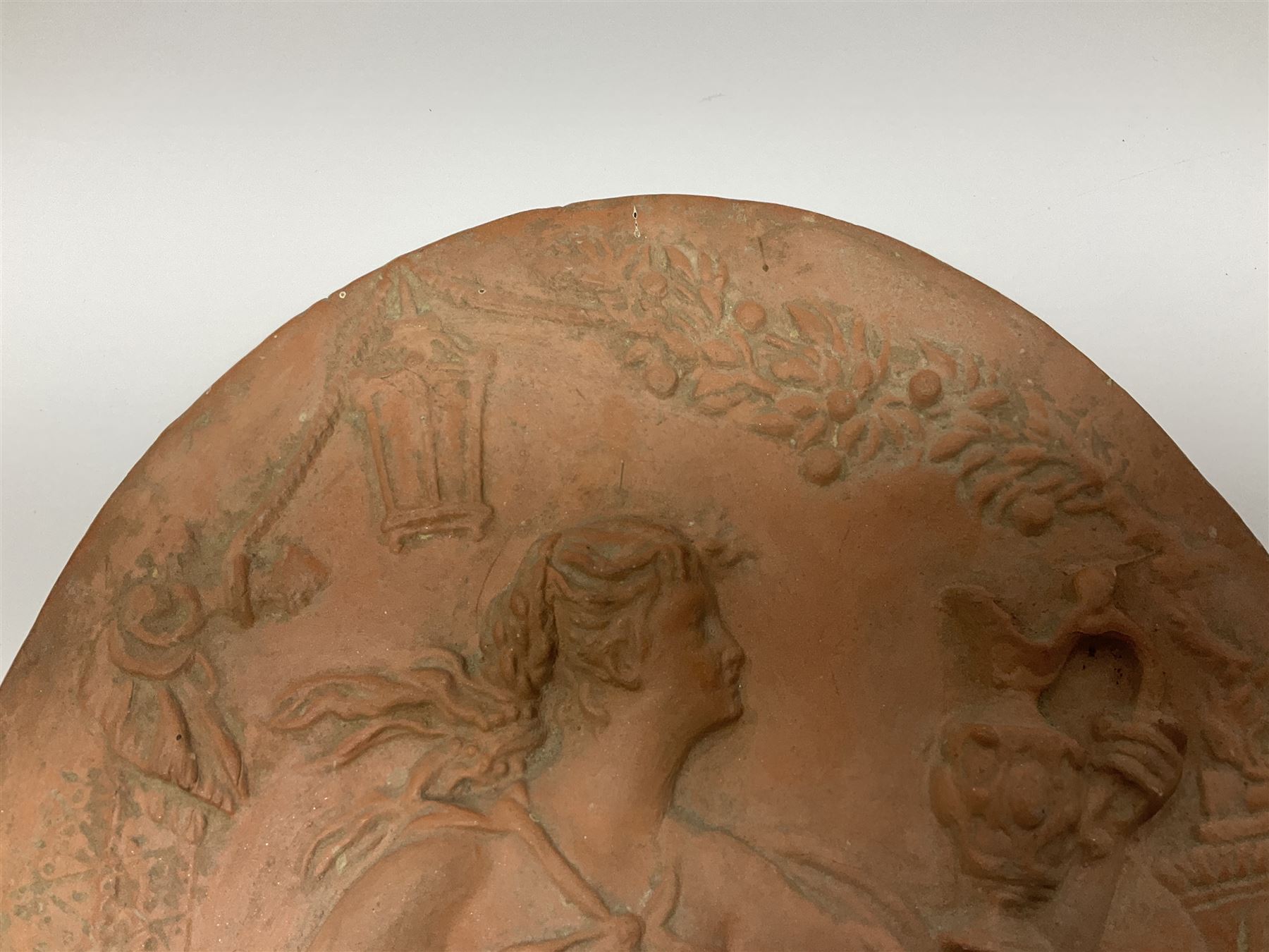 Pair of 19th century classical terracotta relief wall plaques depicting the goddess Hygeia and another goddess, seated holding an ewer, each of oval form, indistinctly signed, each stamped Ferreira verso, H42cm, W30cm