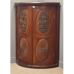  Edwardian mahogany cylinder front corner cupboard, projecting cornice, two panelled doors with carved oval mounts, initials and date 'WHP' and '1908' enclosing two shleves, W95cm, H124cm, D72cm  