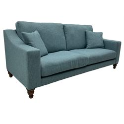 Large two seat sofa upholstered in denim blue fabric, turned dark oak feet, with scatter cushions