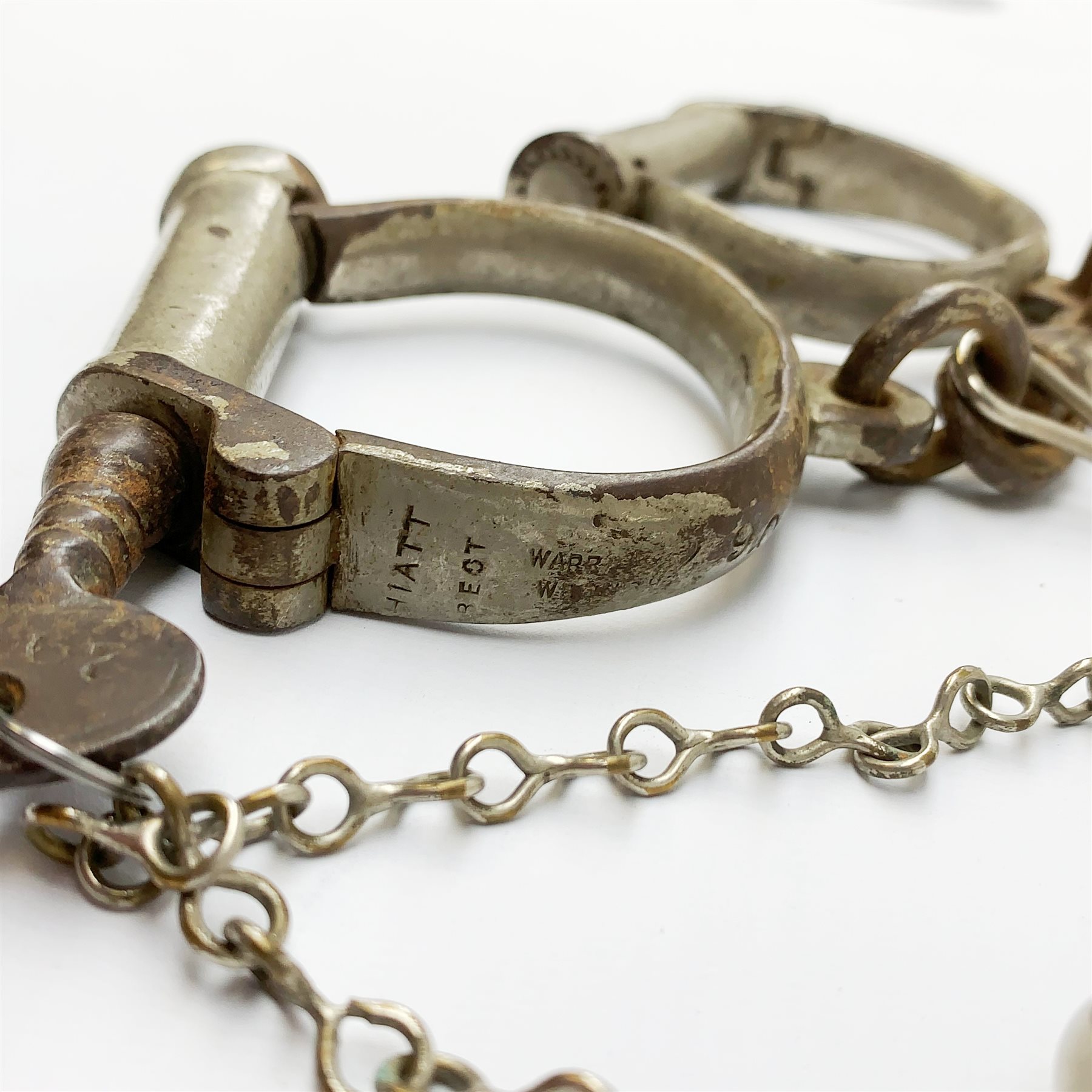 Pair of 1920's Hiatt nickel plated handcuffs marked 'Warranted Wrought' with screw-in key and a 'Metropolitan' whistle