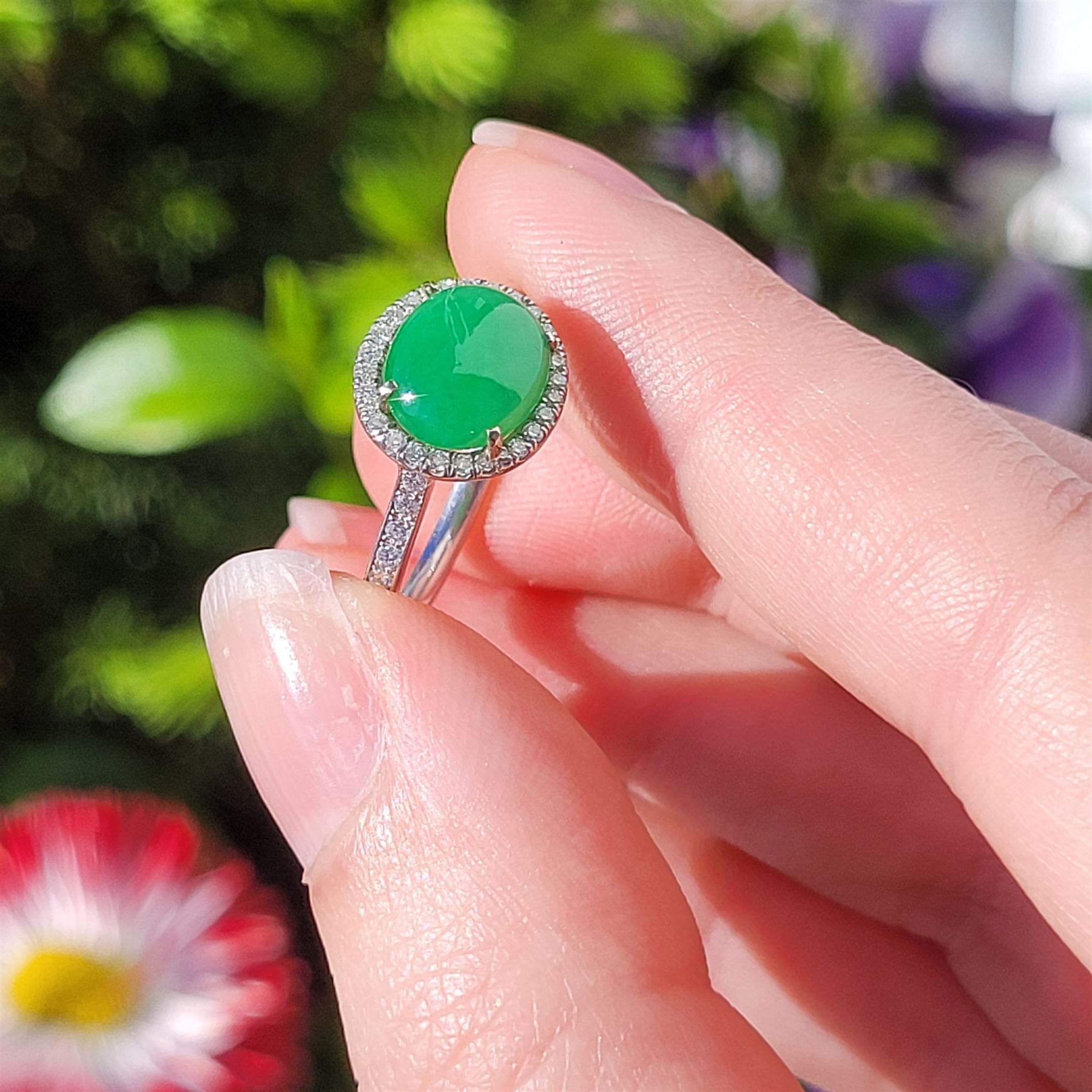 Platinum jadeite and diamond cluster ring, single oval cabochon cut jadeite of 2.20 carat, surrounded by round brilliant cut diamonds and diamond set shoulders, stamped Plat