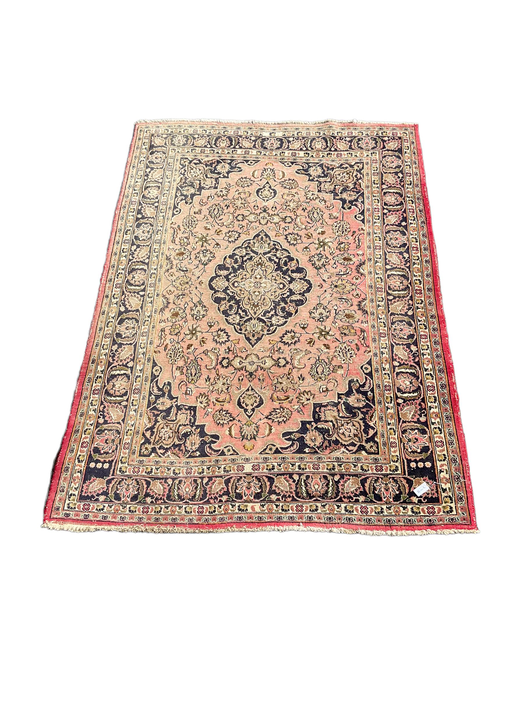 Persian Kashan carpet, blue shaped medallions and spandrels, the field decorated with interlacing branch and stylised plant motifs, repeating floral design borders