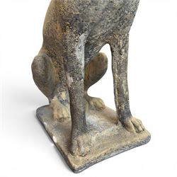 Pair of cast stone hunting pointer dogs in seated poses raised on rectangular bases, in antique weathered finish