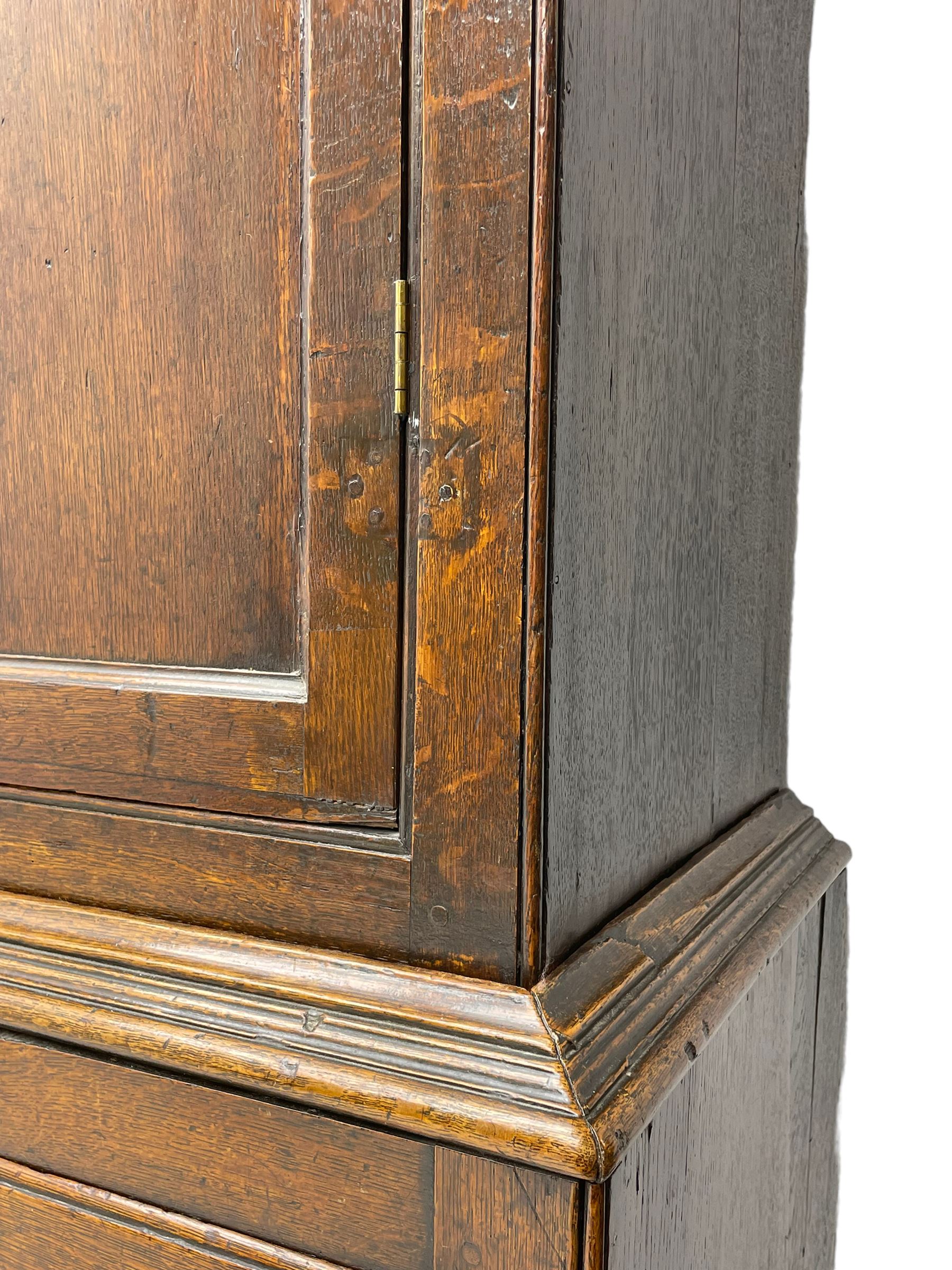 George III oak livery cupboard, projecting moulded cornice over two panelled doors, the upper panels within stepped ogee and arched moulded frame, the interior fitted with a single row of wooden hooks, two short and one long drawers, on bracket and return skirted base 