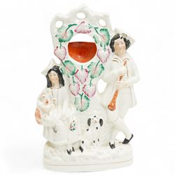 Staffordshire pottery figures including watch stand with piper and companion, pair of dogs and pups, pair of fish sellers and two others