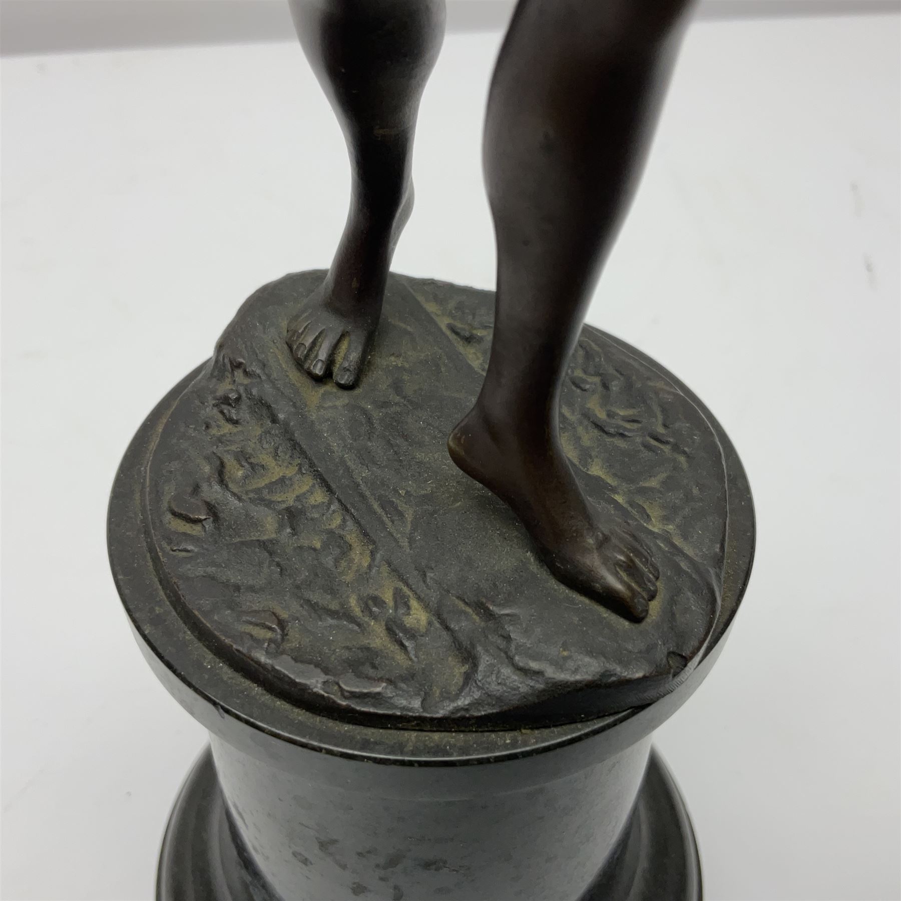 Bronze figure modelled as a nude woman with one arm raised a crescent moon upon her forehead, raised upon a circular stepped plinth, H36cm