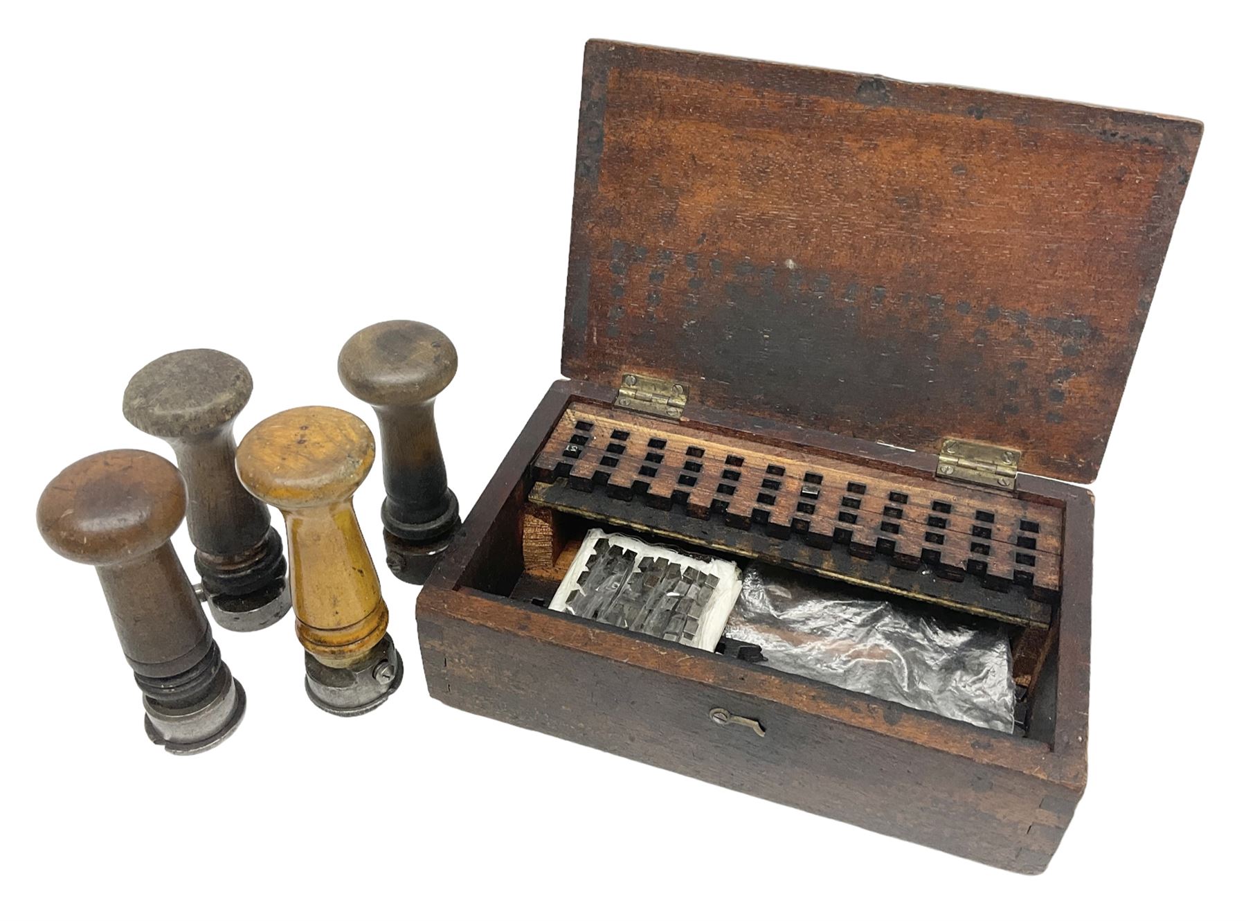 Two Post Office hand stamps 'Heversham Milnthorpe Cumbria' and 'Cimla Neath', together with two hand stamp bodies and various date numbers, housed in a fitted box