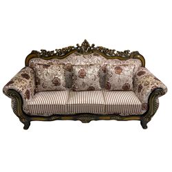 Italian Baroque design three seat sofa, hardwood framed, the cresting rail carved and pierced with c-scrolls and flower heads, scrolled arms, upholstered in floral patterned and striped fabric, with scatter cushions 