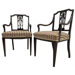 Edwardian mahogany framed three-piece salon suite - two-seat sofa, stepped cresting rail over acanthus and scroll carved pierced splat, upholstered in striped fabric (W124cm, H87cm, D62cm); and a pair of matching armchairs (W60cm) 