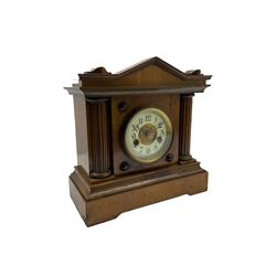 A light mahogany eight-day striking German mantle clock manufactured in the late 19th century by the Hamburg American Clock Company, striking the hours and half-hours on a coiled gong, two-part cream enamel dial with a decorative and gilded center, Arabic numerals, minute track and steel hands, in an architectural designed case with a gable pediment and reeded columns flanking the dial, on a shaped and moulded plinth. 
With pendulum and key.
