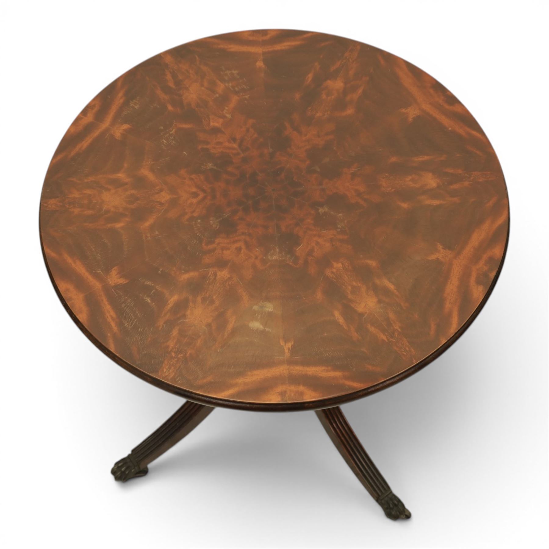 Pair of Georgian design flame mahogany wine tables, circular book-matched veneered tops with moulded edges, on turned pedestals and four reeded downswept supports terminating in brass caps and castors