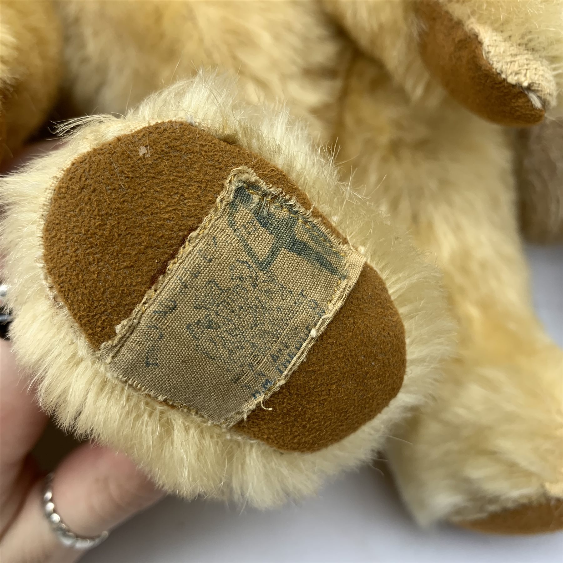  A group of four teddy bears, to include a small Steiff example with button to ear, and a Chad Valley example with label to foot, each with jointed limbs and glass eyes.   