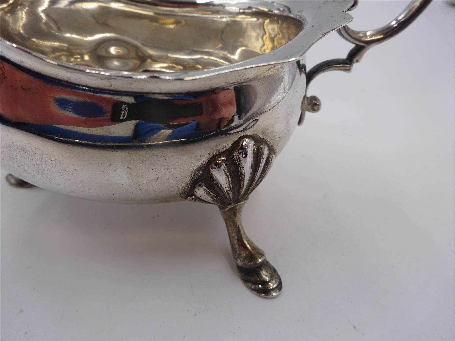 Pair of silver sauce boats, of typical plain form, with acanthus capped flying scroll handle and each upon three hoof feet, hallmarked Walker & Hall, Birmingham 1901, H9cm