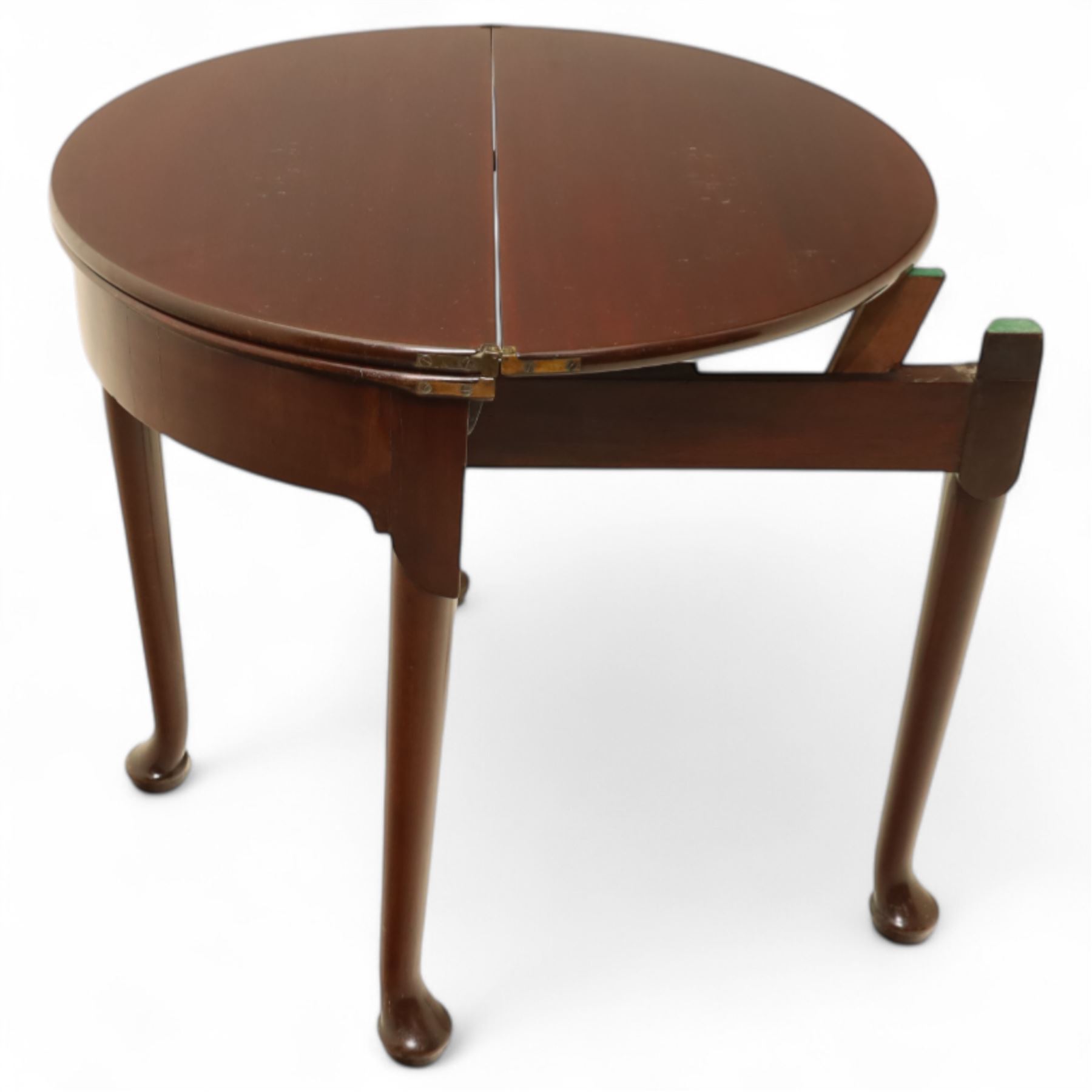 20th-century Georgian Revival style double fold-over card table, the first hinged circular top with polished mahogany surface above a second hinged circular top revealing a green baize playing surface with four counter-wells, underneath with a recessed compartment with and  chip and dice wells, the apron with fitted lock and key, raised on slender straight legs with pad feet 