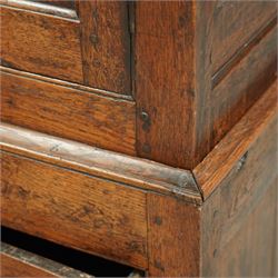 Georgian rustic oak housekeeper’s cupboard, moulded cornice above a pair of fielded panel cupboard doors enclosing a boarded interior with central divider and hanging hooks, the base fitted with two long drawers with brass swan neck handles, raised on stile supports