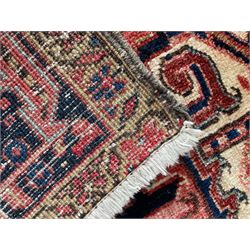 Persian Heriz red ground rug, large medallion decorated with palmettes and Ejder motifs, the border decorated with stylised plant motifs, within floral design guard stripes 