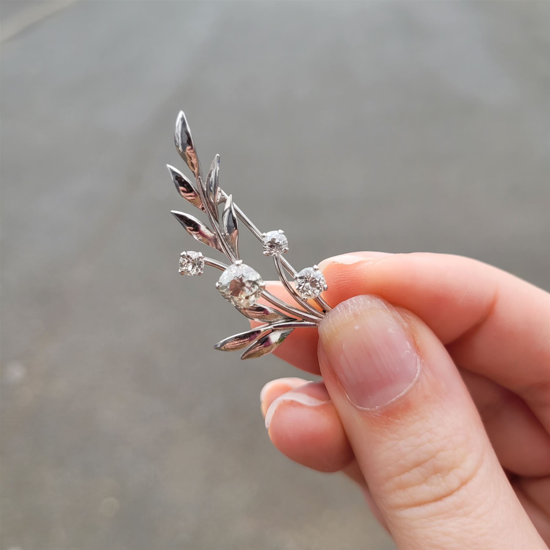 18ct white gold diamond flower brooch, set with a principal old cut diamond of approx 1.00 carat, surrounded by three further old cut diamonds, total diamond weight approx 1.75 carat