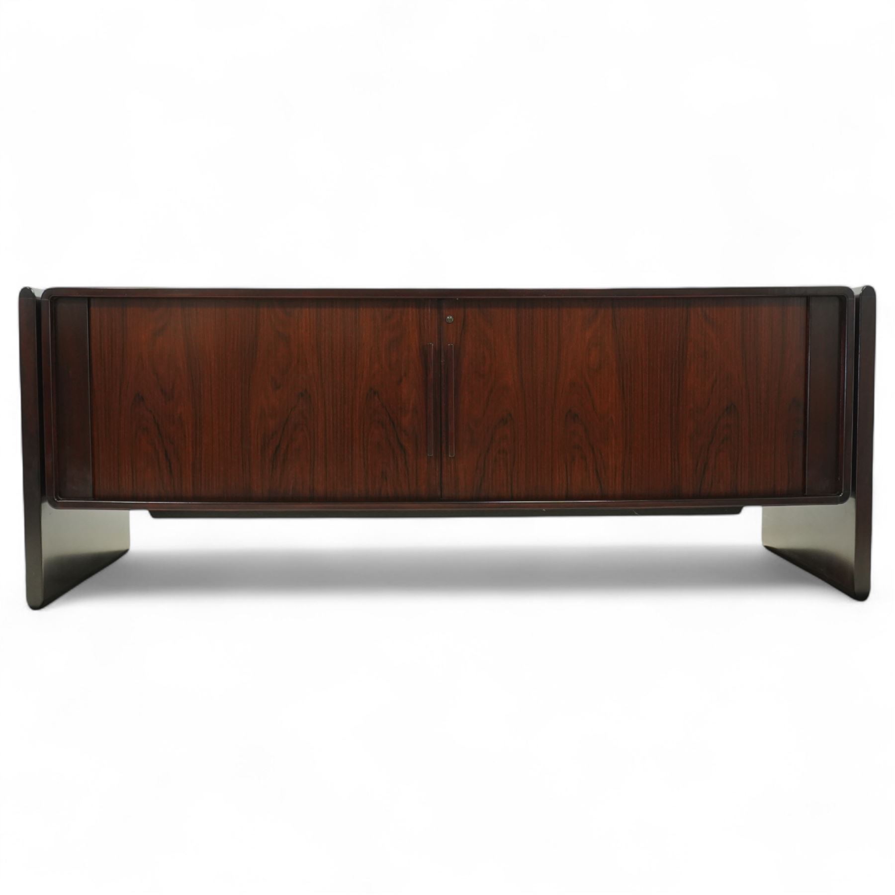 Dyrlund  - contemporary Santos rosewood office sideboard of minimalist form with clean lines, rectangular top with integrated side supports, left side with two drawers, and right side with a filing drawer, all enclosed by sliding doors


Note: Dyrlund is a Danish furniture manufacturer known for its high-quality, handcrafted pieces, particularly in the mid-century modern style. Founded in 1960 by Frits Hjerte Dyrlund in Rude, Denmark, the company has remained a family business, now run by the second and third generations. Dyrlund specializes in both home and executive office furniture, focusing on practicality, solid construction, and classic design. 
