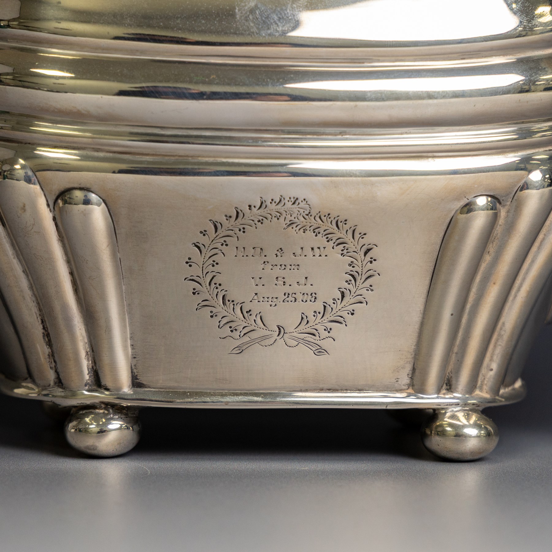 Edwardian silver teapot, of part fluted oval form upon four bun feet, with ebonised handle and finial and presentation engraving to body, hallmarked Thomas Bradbury & Sons, London 1904, H17cm