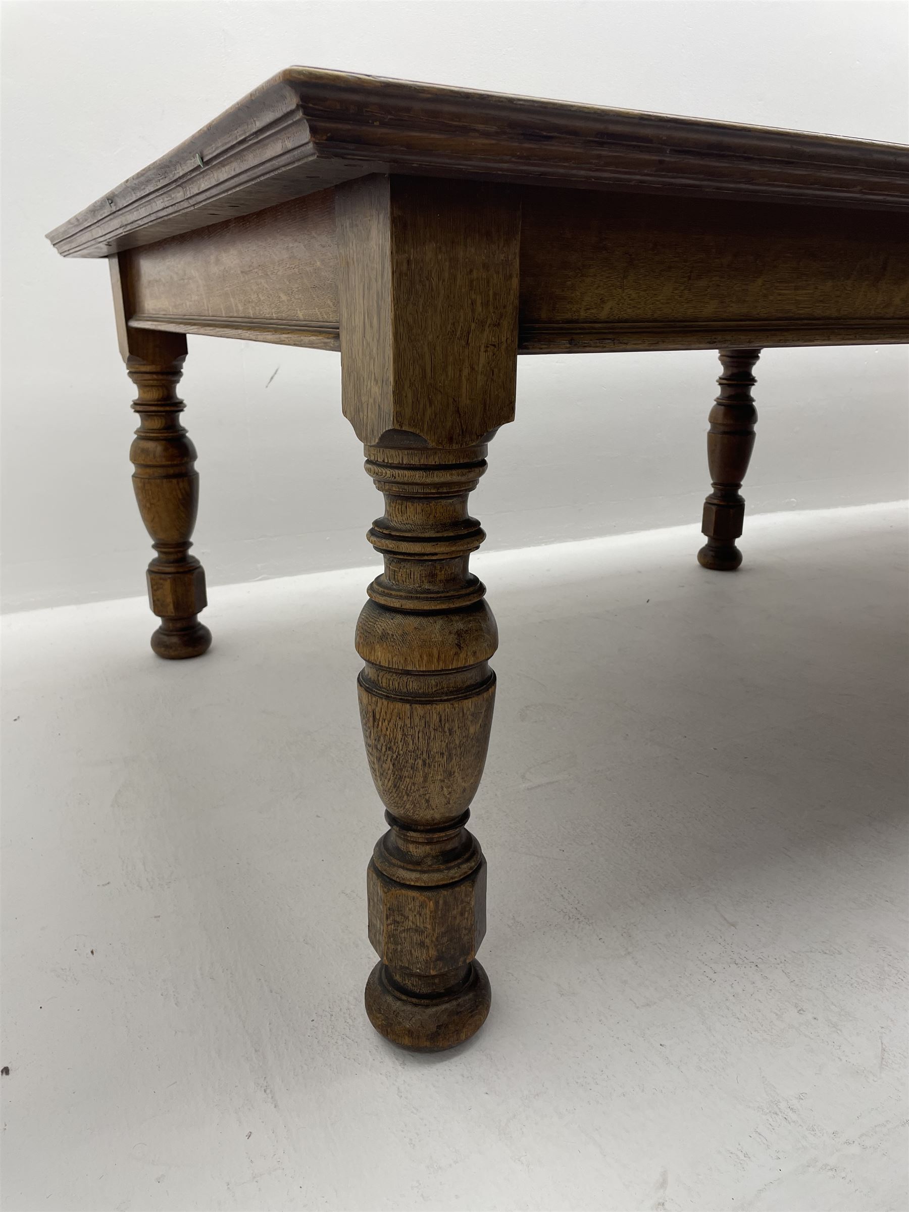 Large early 20th century oak boardroom table, rectangular moulded top on six turned and faceted supports 