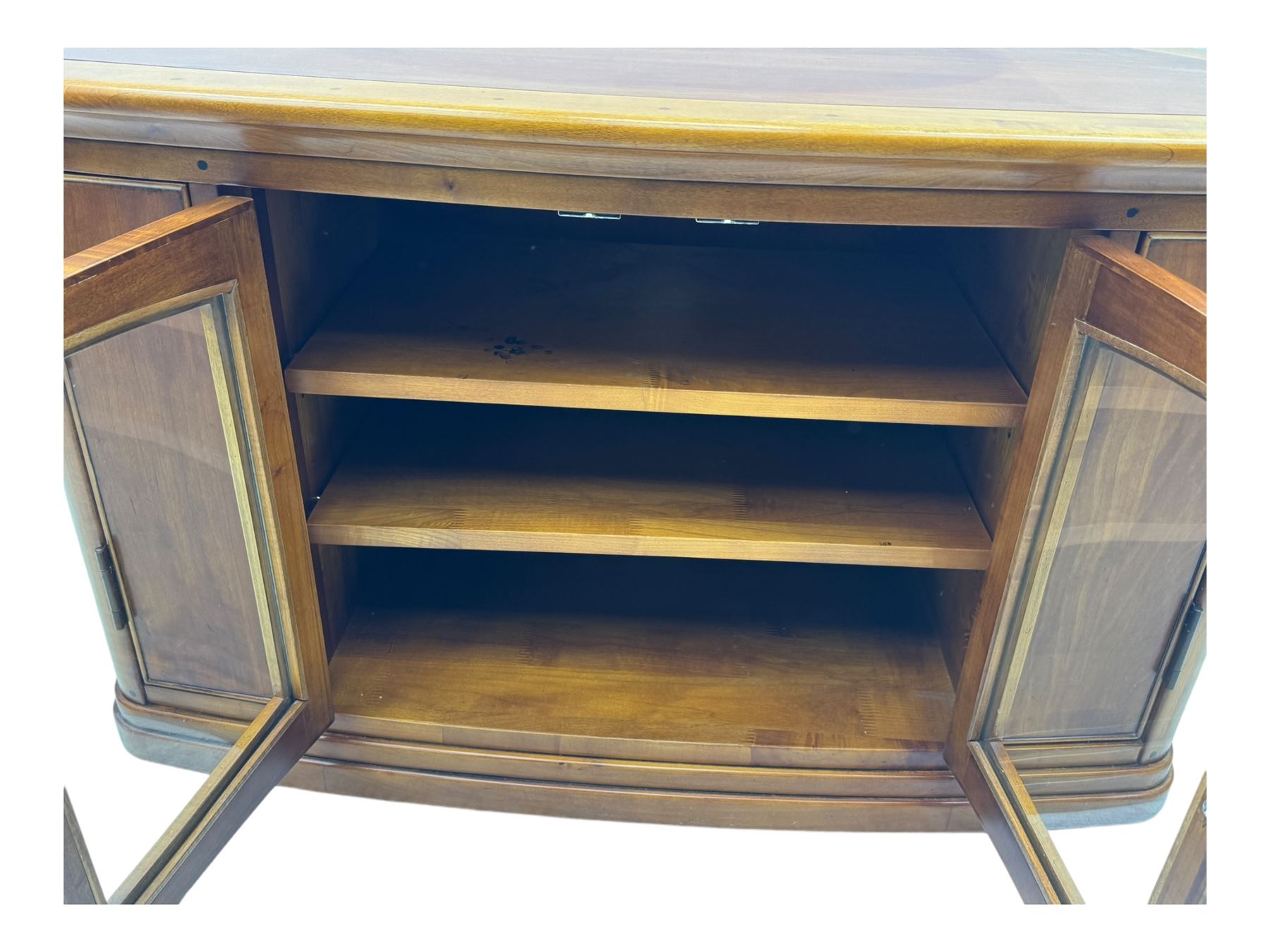 Contemporary cherry wood corner TV unit, canted top over central glazed double doors opening to shelves for media storage, flanked by side storage compartments, on a plinth base