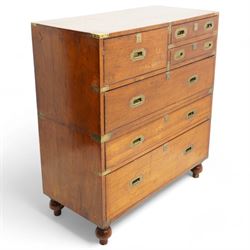 Early 19th century and later teak military campaign chest, mounted and bound with brass strapping and corner brackets, fitted with one deep, two shallow and three long drawers, each with recessed brass handles and shaped escutcheons, on turned feet 