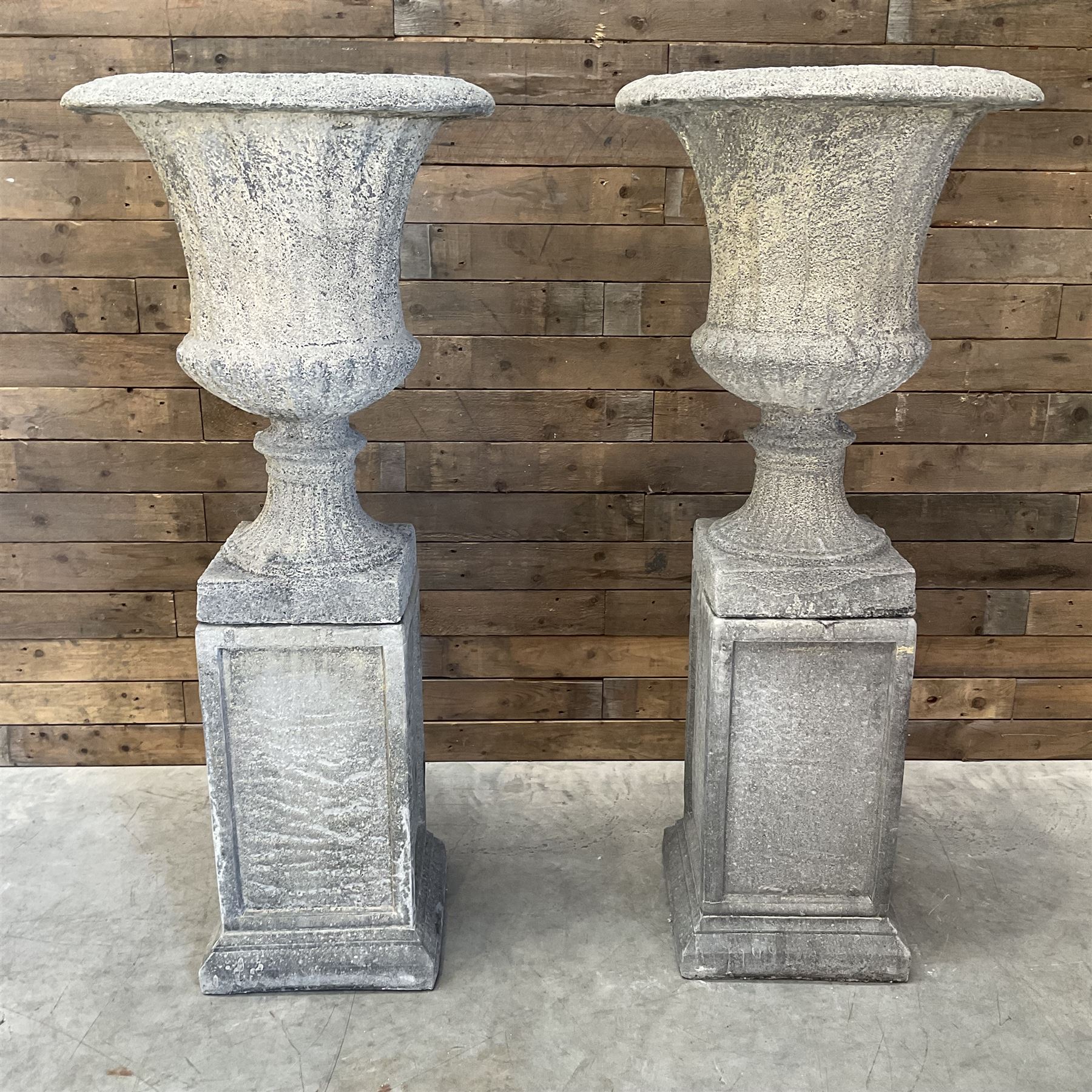 Pair of large Georgian design cast stone garden urns, egg and dart border, tapering column on square base, raised on square column