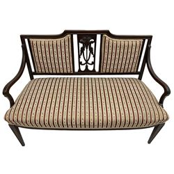 Edwardian mahogany framed three-piece salon suite - two-seat sofa, stepped cresting rail over acanthus and scroll carved pierced splat, upholstered in striped fabric (W124cm, H87cm, D62cm); and a pair of matching armchairs (W60cm) 