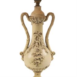 Table lamp modelled as a twin handled urn, decorated in relief with floral sprigs, upon a stepped rectangular base, with a cram lampshade, H53cm, without lampshade 