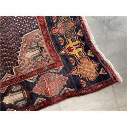 Persian Hamadan blue ground rug, medallion on field decorated with repeating motifs, the guarded border with multiple medallions decorated with flower heads and stylised motifs