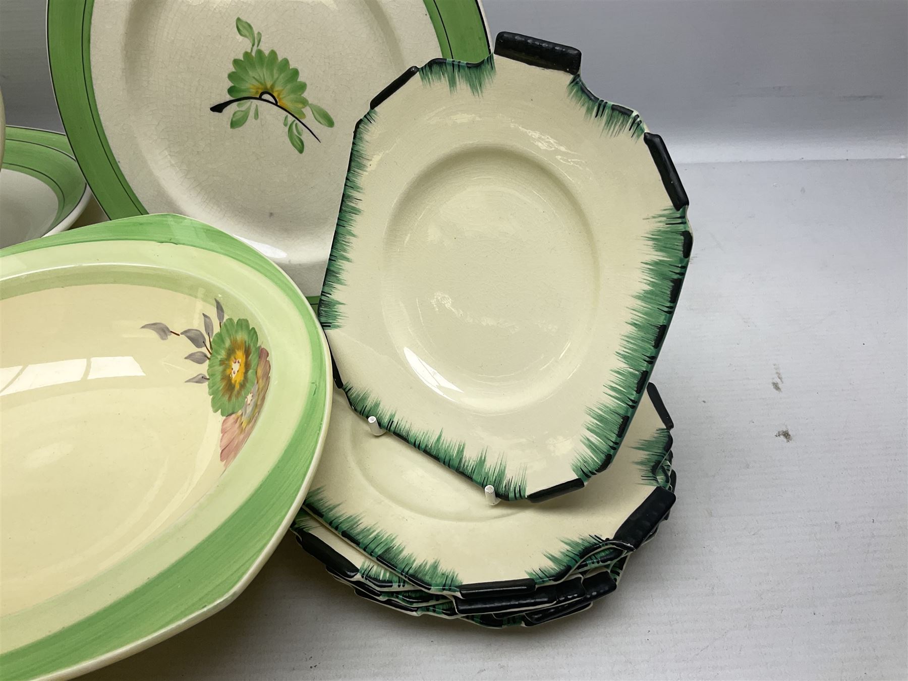 Clarice Cliff for Newport Pottery Corolla pattern tea and dinner wares, comprising triangular bowl, four side plates, two shallow bowls and teacup (a/f), together with a Clarice Cliff Wilkinson twin handled soup bowl and unassociated saucer both decorated with pink and yellow flowers, together with other mid century ceramics comprising Parrott and Company Coronet Ware, and Royal Staffordshire AJ. Wilkinson Ltd dinner wares