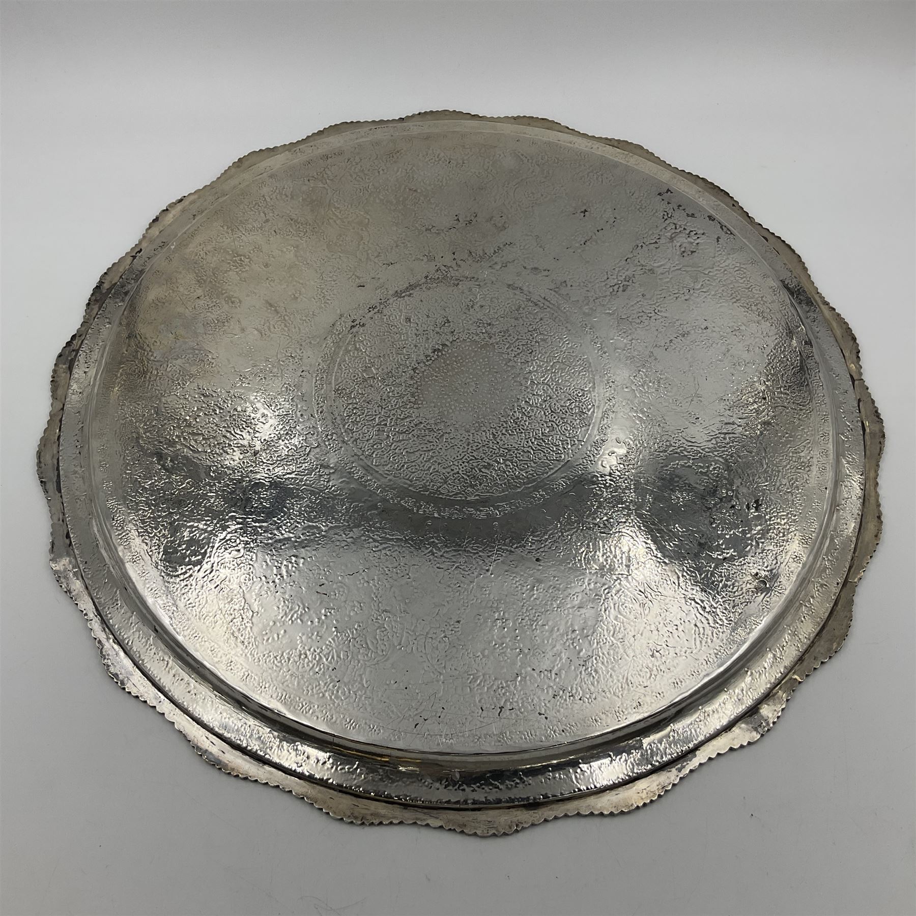 Early/mid 20th century Persian silver tea service, comprising circular serving tray, teapot, twin handled sucrier and cover, milk jug, five tea glasses with six silver holders, six tea spoons, and pair of sugar tongs, each profusely chased with foliate arabesque decoration, each bearing marks including 84 for 840 fineness, tray D40cm, teapot H16cm
