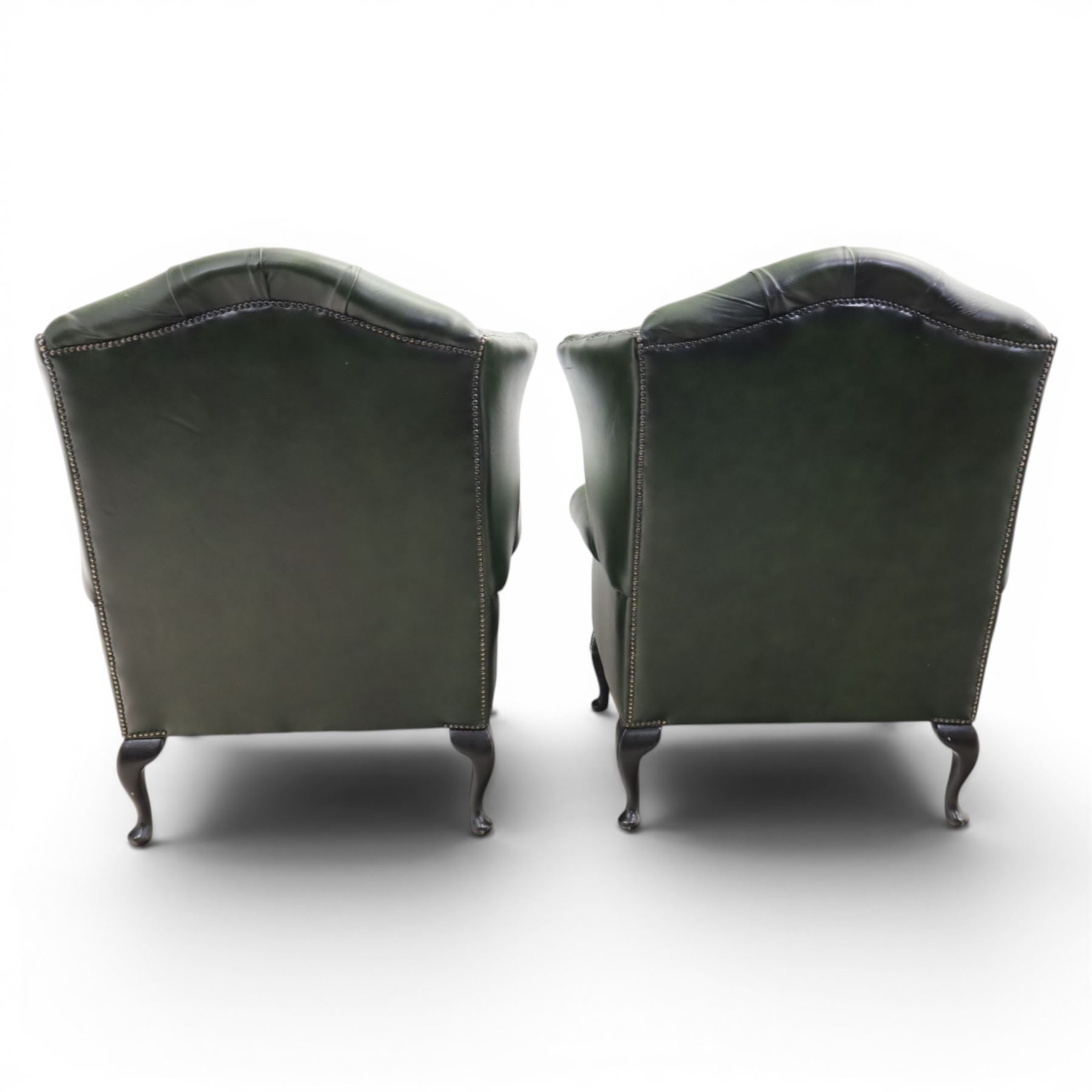 Thomas Lloyd - Pair of Queen Anne design wingback armchairs upholstered in buttoned green leather, button back and scrolled arms, raised on cabriole supports. 