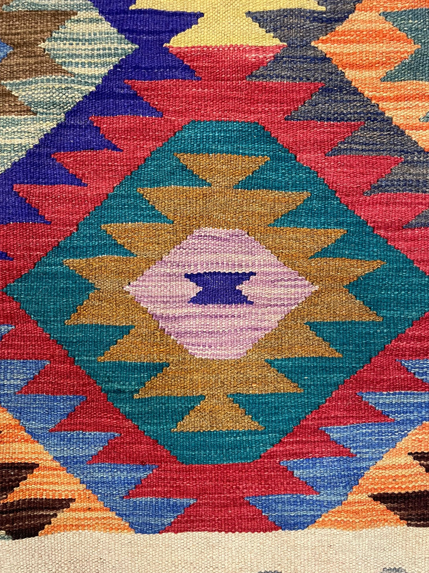 Anatolian Turkish Kilim rug, multi-coloured ground, decorated with geometric stepped lozenges with in a scrolled border