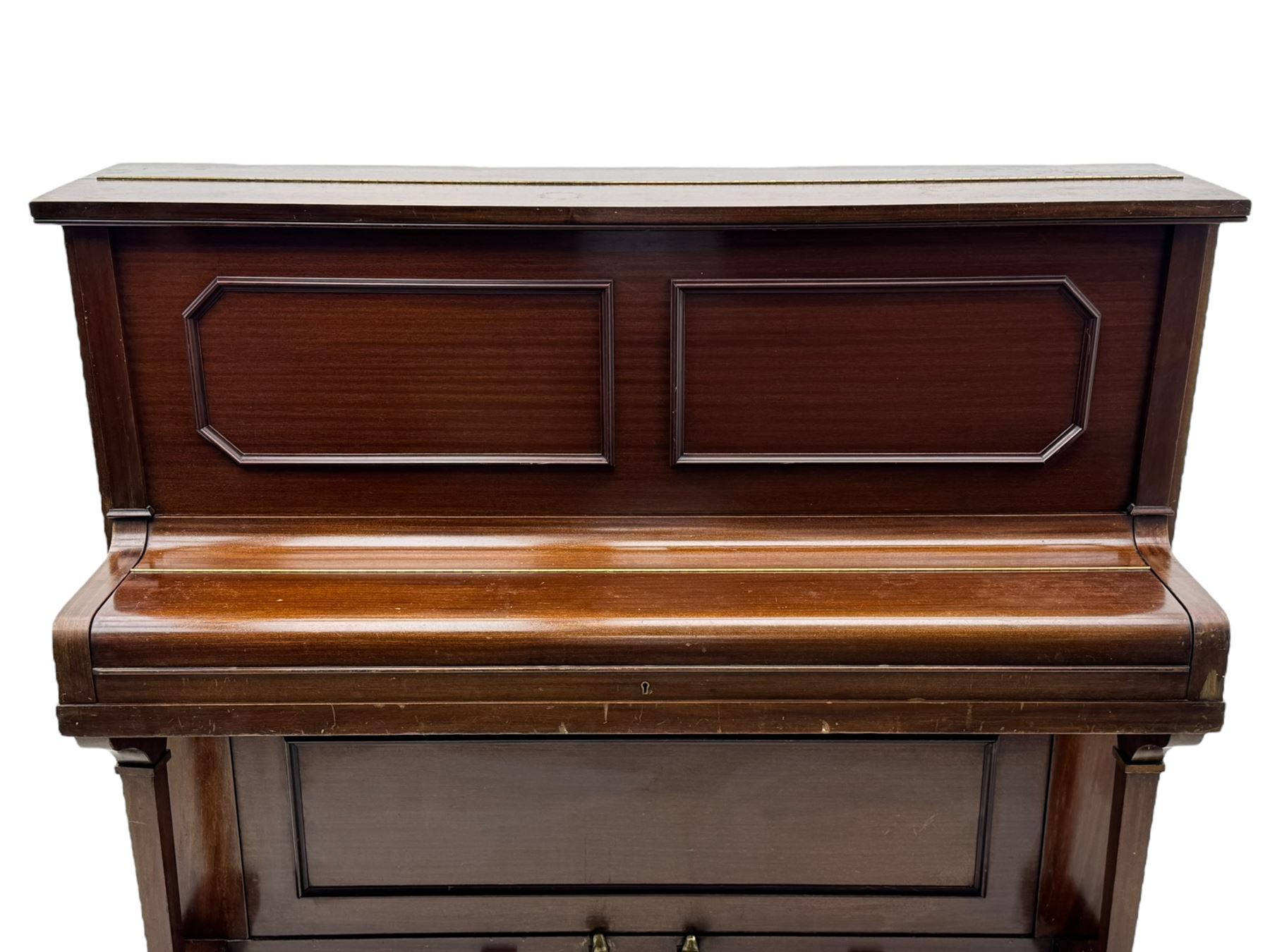 Waddington - Edwardian mahogany upright piano, rectangular top with panelled front, rounded key cover, makers name on fallboard, raised on bracket supports with castors