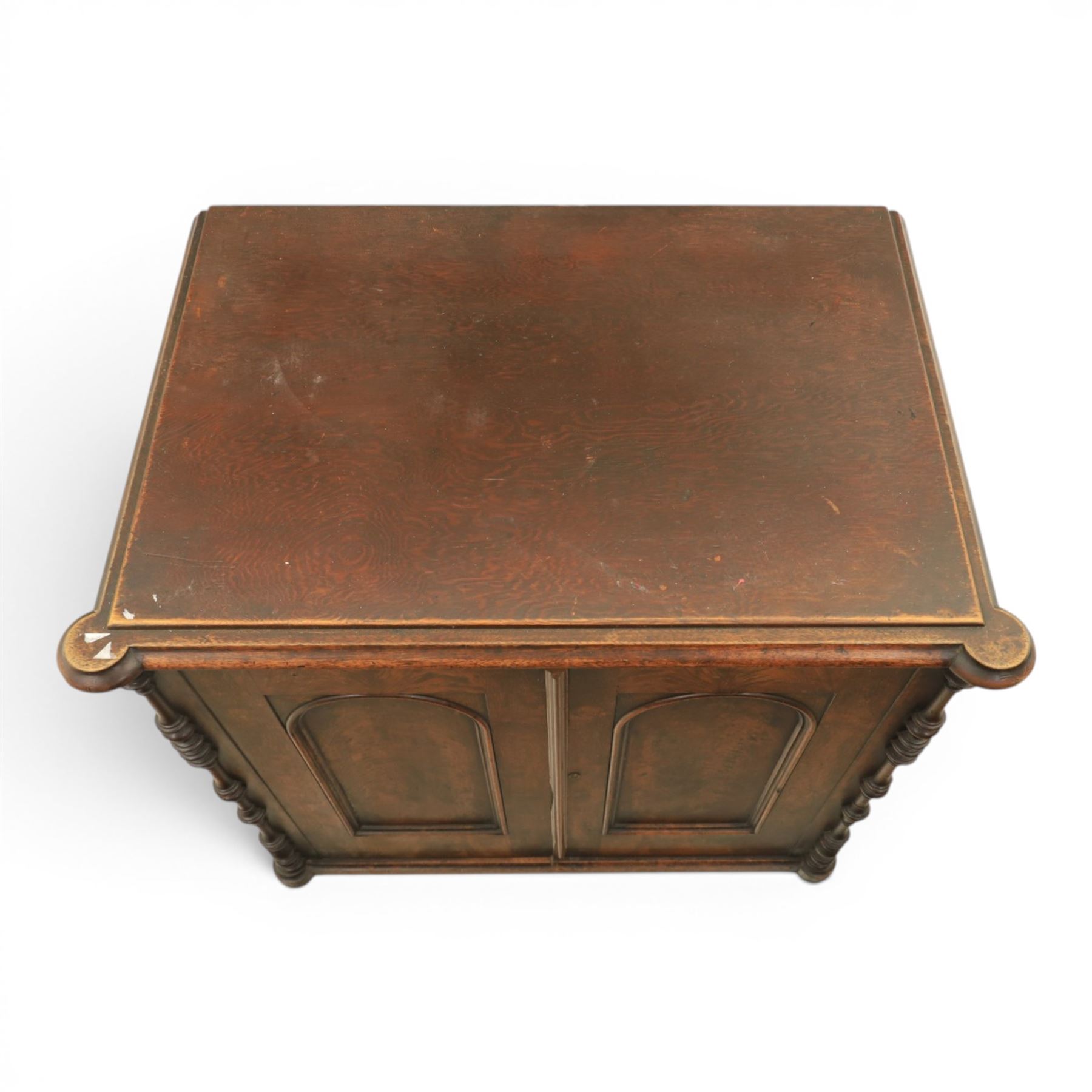 Victorian mahogany low cabinet, shaped rectangular top fitted with two arch panelled doors flanked by turned pilasters, enclosing two shelves and fitted with four short drawers with turned knobs 