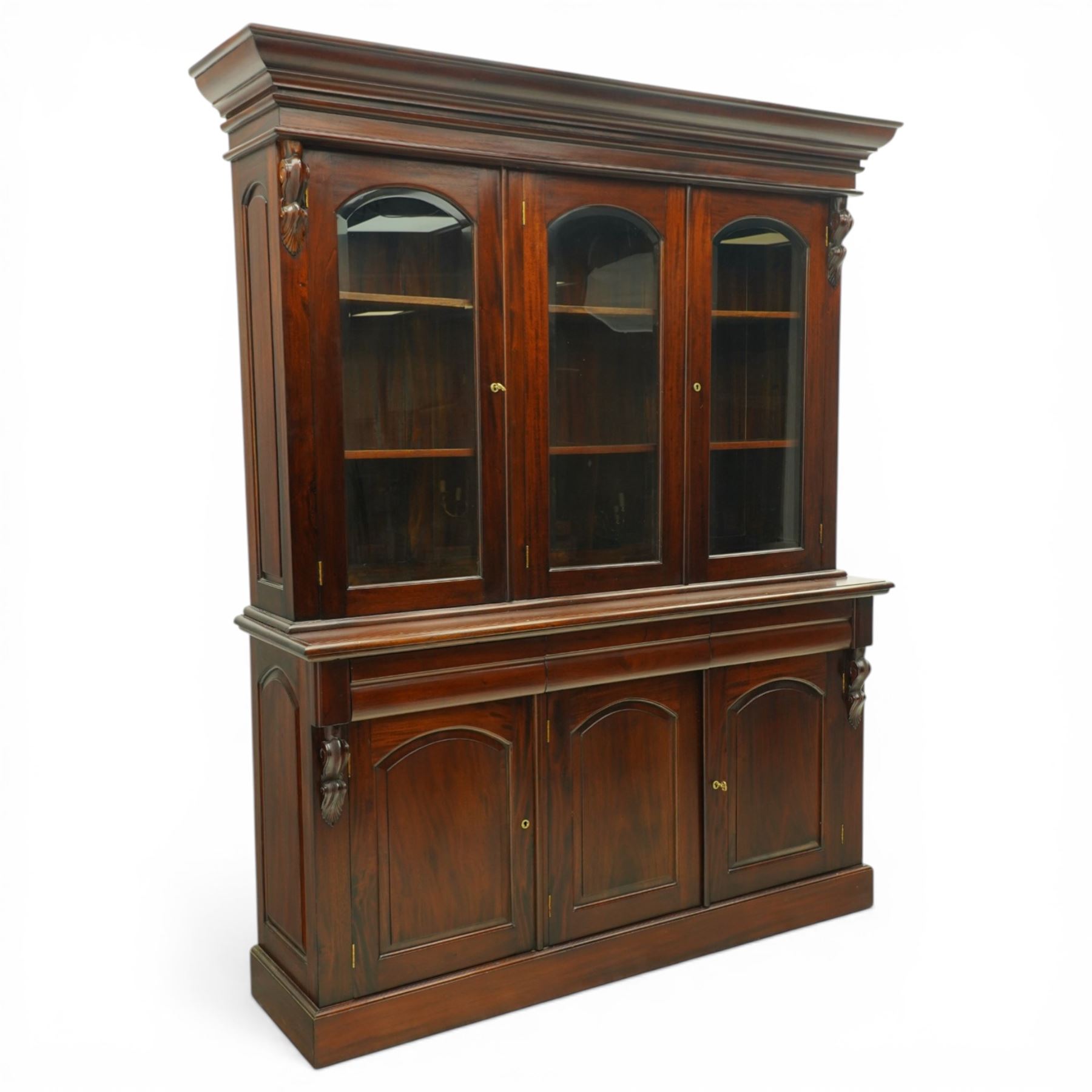 Victorian revival hardwood dresser, projecting moulded cornice above three glazed doors enclosing shelves, moulded top over three drawers and three panelled cupboard doors, flanked by applied carved scroll brackets, on plinth base,