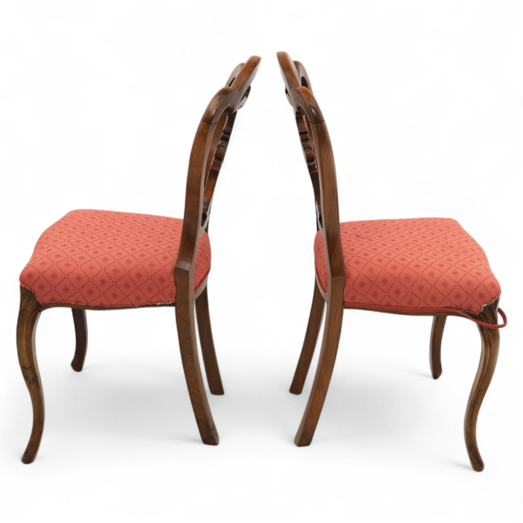 Set of four Victorian walnut balloon back chairs, with a carved and pierced back splat with foliate scrolls, serpentine seat upholstered in a diamond pattern fabric, raised on cabriole legs 