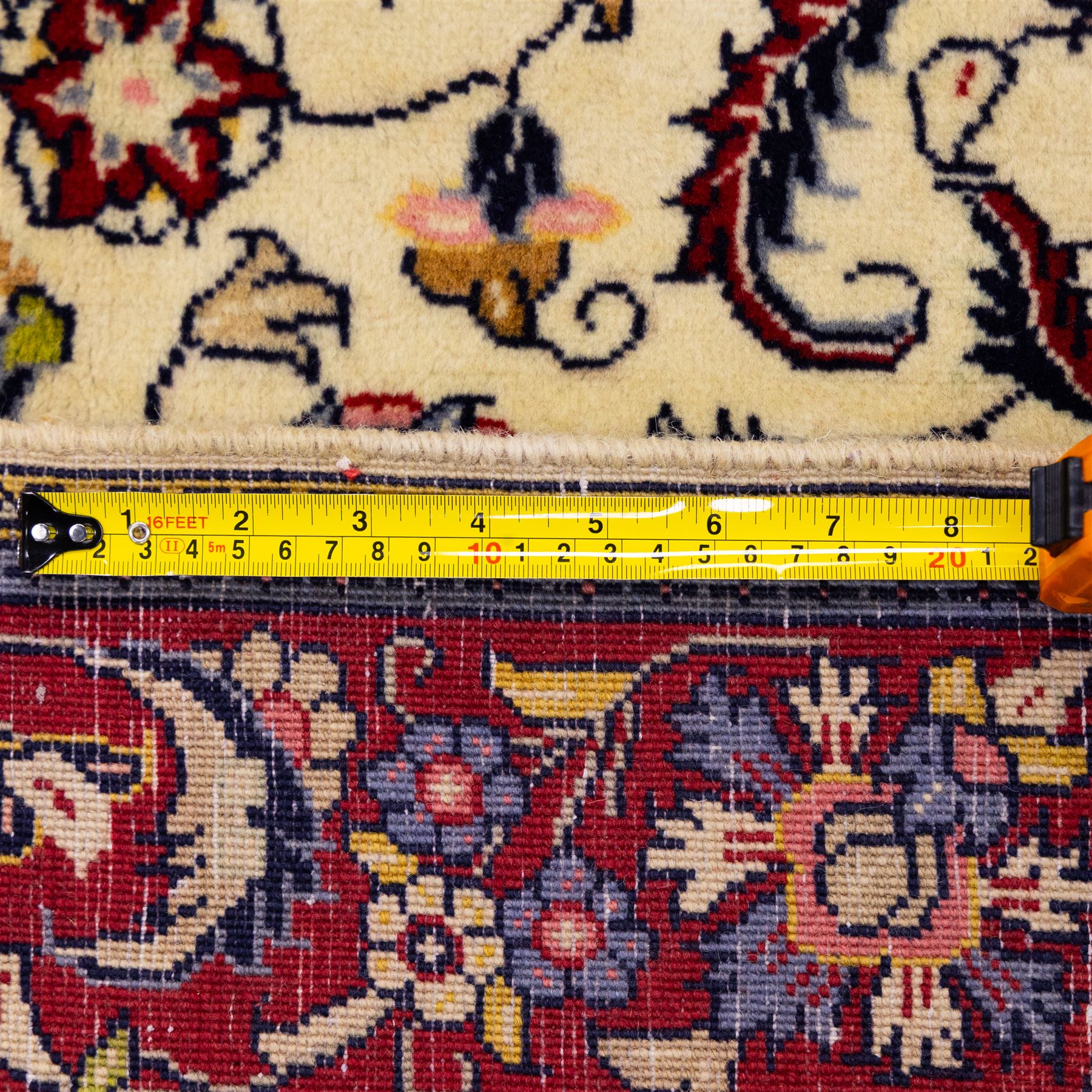 West Persian Sarough hand-knotted rug, ivory field decorated with finely drawn symmetrical lattice of scrolling vines, palmettes and flowering sprays issuing from a subtle central medallion, enclosed by a broad madder-red border of stylized palmettes and foliate vine ornament between multiple guard stripes, with cotton fringe ends 