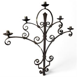 Collection of wrought iron candle stands, comprising five-light and three-light floor-standing candelabra with scrolling branches, and a pair of five-light table candelabra of naturalistic branching form