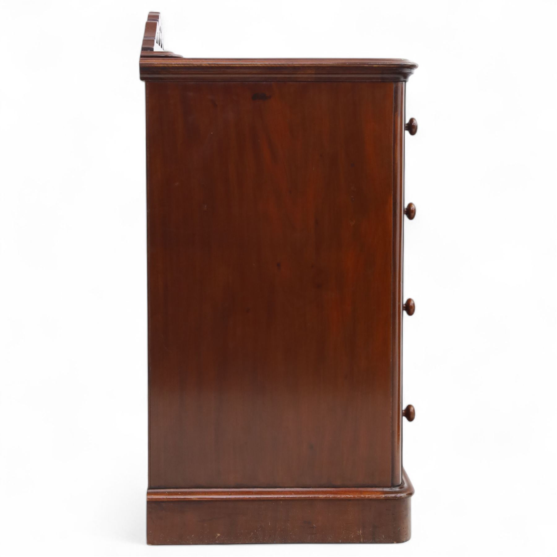 Pair of tall Victorian mahogany bedside chests, of narrow upright form, rectangular top with moulded edge, the back with raised pierced fretwork gallery, above four graduated drawers with knob handles, raised on a plinth base 