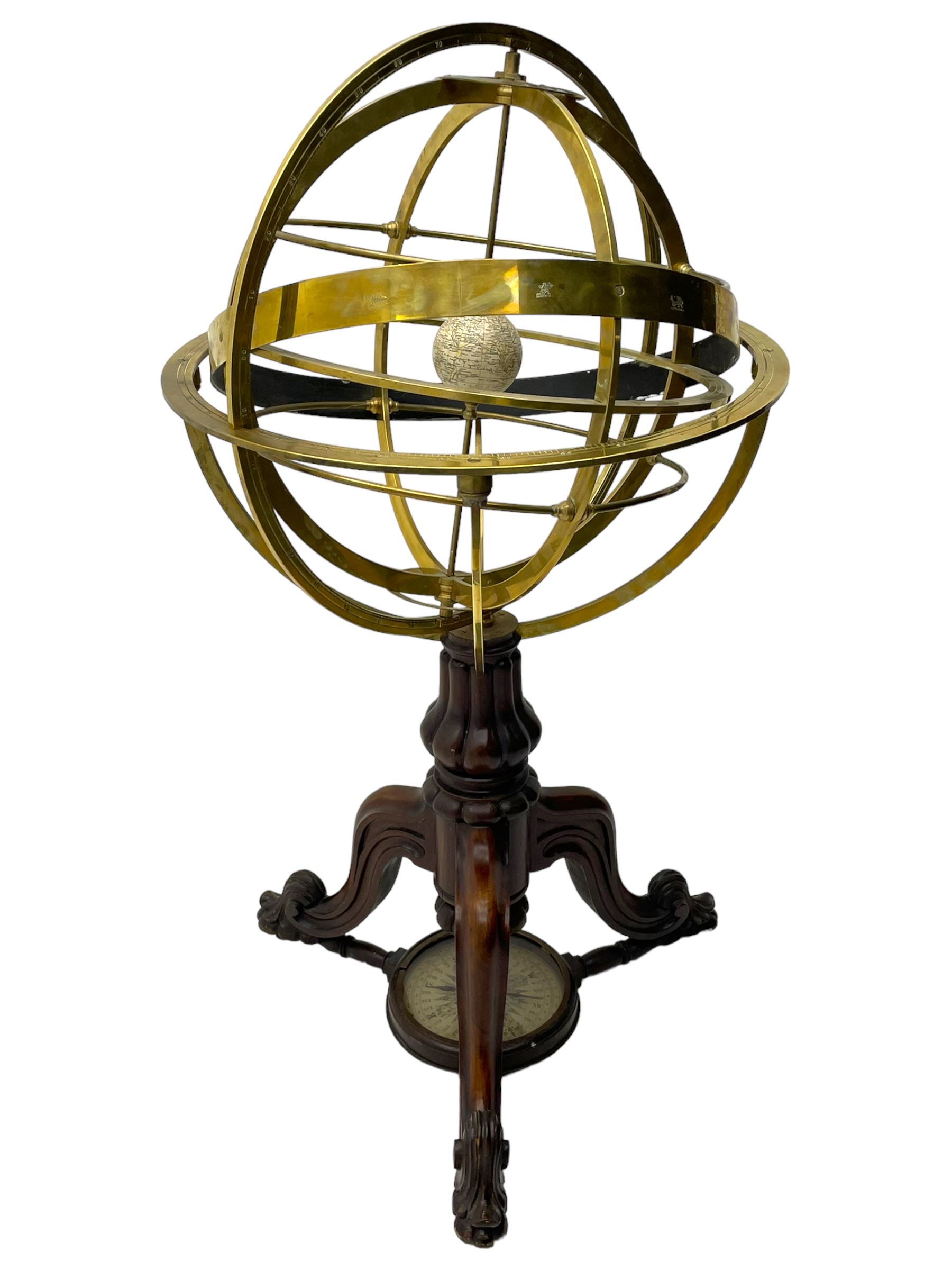 19th century brass terrestrial armillary sphere on rosewood base, lobe carved column on three splayed supports with scrolled carved terminals, the supports united by circular compass with turned stretchers