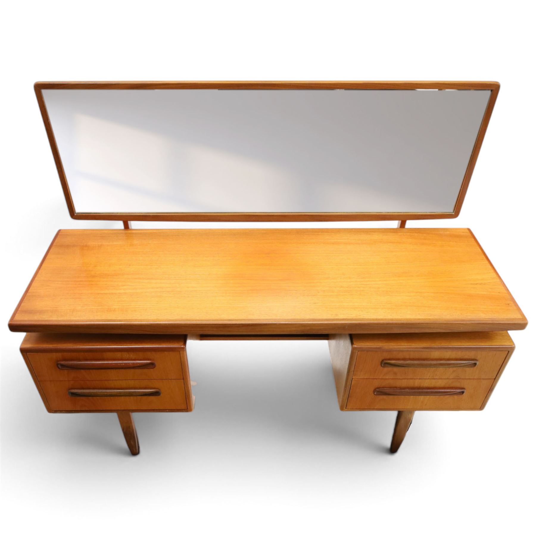 G-Plan - ‘Fresco’ teak dressing table, rectangular top with raised rectangular mirror, fitted with four drawers arranged as twin pedestals with sculpted handles, central knee-hole, on tapering supports