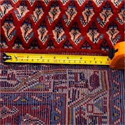 West Persian Saraband (Boteh-Mir) runner madder-red field densely decorated with repeating boteh motifs, arranged in diagonal rows enclosed by a geometric border of stylized motifs, between multiple guard stripes, cotton fringe ends  