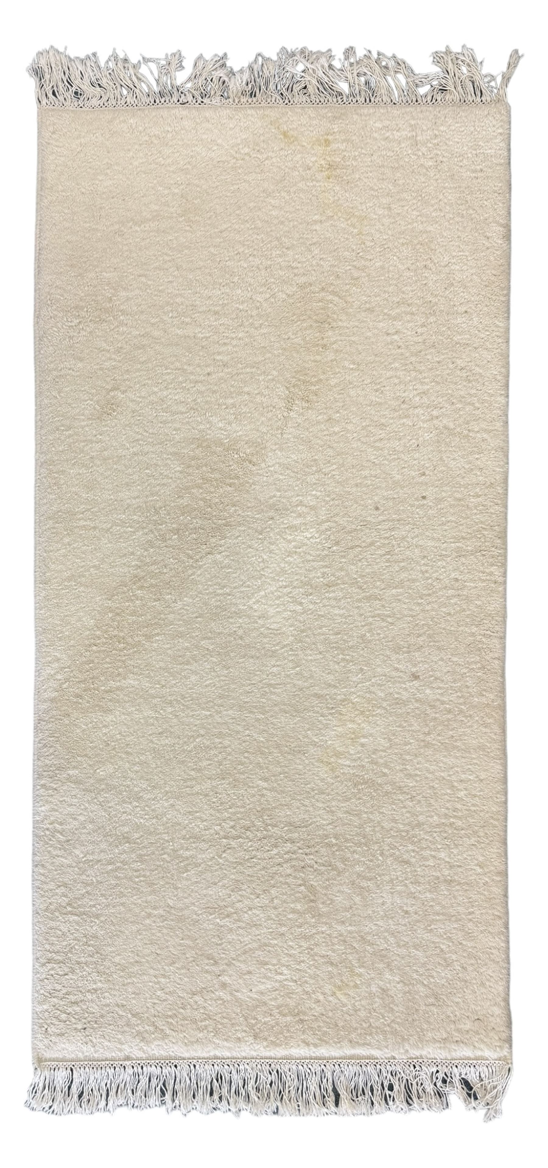 Contemporary Kayam hand-knotted Indian rug, plush wool pile in plain cream, ivory fringed edges on both sides 