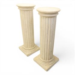 Pair of Regency style composite stone column pedestals, with fluted cylindrical columns and moulded capitals and bases, on square plinths