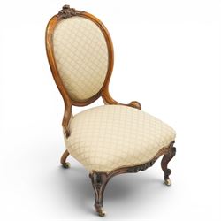 Pair of Victorian walnut framed ladies salon nursing chairs, oval cameo back with carved cartouche carved cresting rail, sprung seat upholstered in foliate patterned ivory fabric, shaped apron carved with scroll and cartouche decoration, on cabriole supports with moulded flower knees, retailed by David Hick Interiors, Jersey